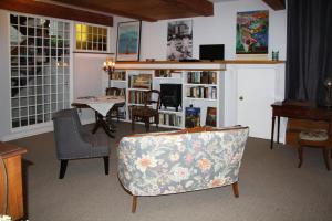 een woonkamer met een bank en een tafel en stoelen bij 2 Moon Cottage in Niagara on the Lake