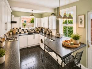 a kitchen with white cabinets and a table and chairs at Central Reading Guest House in Reading
