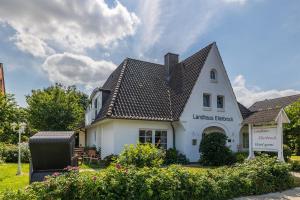 a white house with a black roof at Hotel Landhaus Ellerbrock in Böhl