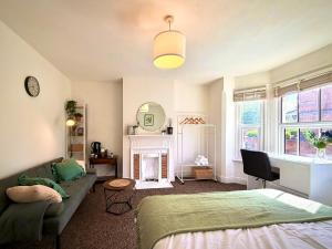 a bedroom with a bed and a couch and a fireplace at Central Reading Guest House in Reading