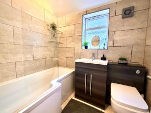 a bathroom with a toilet and a sink and a tub at Central Reading Guest House in Reading +10 photos