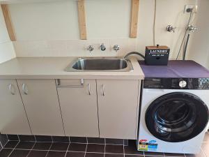 a kitchen with a sink and a washing machine at Hopetoun - footprints in the sand in Hopetoun +77 photos