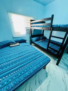 a bedroom with two bunk beds and a ladder at MiKasa Azul Transient House in Cabuyao