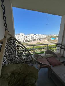 a balcony with a hammock and a view of a beach at AMWAj in El Alamein