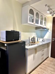 a kitchen with a sink and a microwave at Atelier Studio, Stanford Suites 3, Silang in Silang