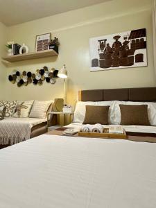 a bedroom with a large white bed and a couch at Atelier Studio, Stanford Suites 3, Silang in Silang +14 photos
