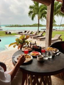 a table with food on it with a view of the ocean at Hotel CasaBakal - A pie de Laguna - Bacalar in Bacalar