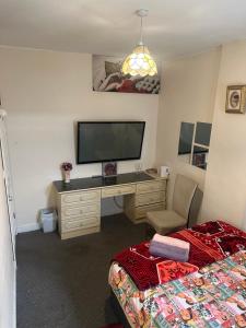 a bedroom with a desk with a television and a bed at Quiet Nest 2 in Coventry