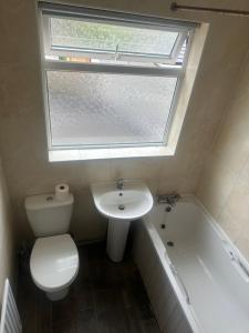 a bathroom with a toilet and a sink and a window at Quiet Nest 2 in Coventry