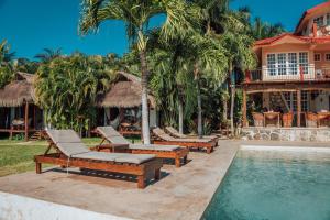a resort with a pool with lounge chairs and a house at Hotel CasaBakal - A pie de Laguna - Bacalar in Bacalar
