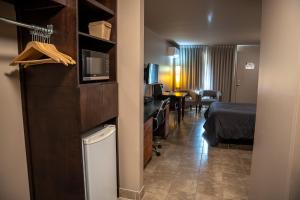 a hotel room with a bed and a desk with a microwave at Motel Le Martinet in La Pocatiere