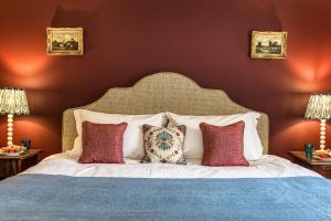 a bedroom with a large bed with red walls at Roft Bank Cottage in Oswestry