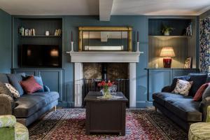a living room with two couches and a fireplace at Roft Bank Cottage in Oswestry
