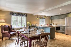 a kitchen with a wooden table and chairs and a kitchen with a counter at Roft Bank Cottage in Oswestry