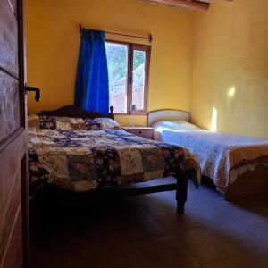 a bedroom with two beds and a window at El Rincón de la Quebrada in Tilcara