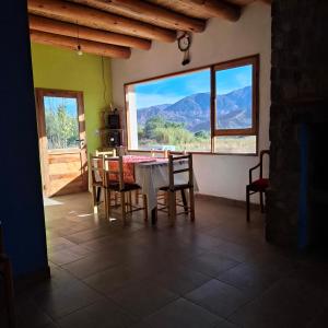 a dining room with a table and chairs and a large window at El Rincón de la Quebrada in Tilcara