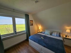 a bedroom with a large bed and a large window at Ferienhaus Seeschwalbe in Tossens