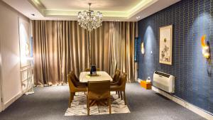 a dining room with a table and chairs and a chandelier at Mac Residence in Lagos