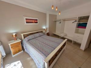 a bedroom with a large bed and a night stand at Departamentos Atlantic in Monte Hermoso