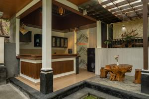 a porch with a wooden table and a kitchen at Bumbung Sari Villa in Ubud