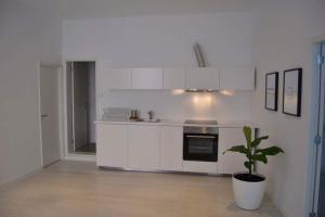 a white kitchen with a potted plant in a room at Charming Apartment 101 in Funchal