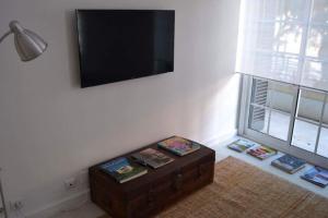 フンシャルにあるCharming Apartment 101のテレビ、テーブル(本付)が備わる客室です。