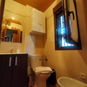 a bathroom with a toilet and a sink and a window at Alborada in Pinos Genil +29 photos