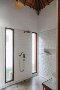 a bathroom with a shower in a white wall at Markisa Villas - Spacious Private Pool Homes on Gili Air in Gili Islands