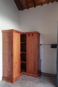 a wooden cabinet in a room next to a refrigerator at Markisa Villas - Spacious Private Pool Homes on Gili Air in Gili Islands