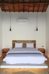 a bedroom with a large white bed with two pillows at Markisa Villas - Spacious Private Pool Homes on Gili Air in Gili Islands