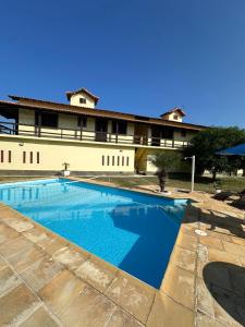 a large swimming pool in front of a building at Casa Bella Itaúna Suites in Saquarema