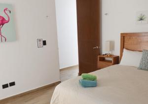 a bedroom with a bed with a green towel on it at Telchac 3 bedrooms, pool and beach in Telchac Puerto