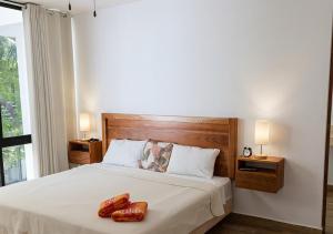 a bedroom with a bed with two shoes on it at Telchac 3 bedrooms, pool and beach in Telchac Puerto