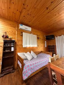 a bedroom with a bed in a wooden cabin at Cabañas Iremía in Uribelarrea