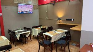 a dining room with tables and chairs and a tv at Hispano Argentino in Buenos Aires