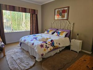 a bedroom with a bed with a floral bedspread at Hopetoun - footprints in the sand in Hopetoun