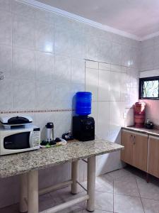 a kitchen with a counter with a microwave on it at Quarto suíte privativo em campinas para 4 pessoas in Campinas +5 photos