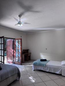 a bedroom with two beds and a ceiling fan at Quarto suíte privativo em campinas para 4 pessoas in Campinas