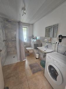 a bathroom with a washing machine and a shower at Ferienhaus Seeschwalbe in Tossens +38 photos
