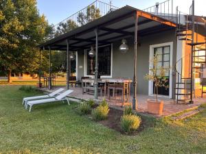 a patio with a table and chairs and a building at Rancho Capilla in Capilla del Señor