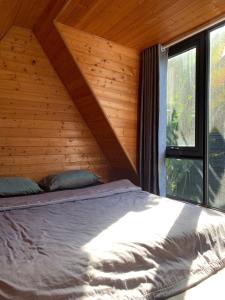 a bed in a wooden cabin with a window at Lang Omm in Tang Klang +22 photos