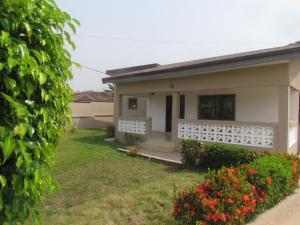 a house with a garden and flowers in the yard at Rams Lodge in Accra