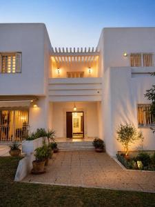a large white house with a staircase in front of it at Villa Marsa in Dar el Haj Ahmed Souid