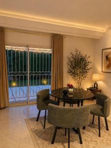 a living room with a table and chairs and a large window at Villa Marsa in Dar el Haj Ahmed Souid