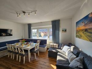 a living room with a couch and a table at Ferienhaus Seeschwalbe in Tossens