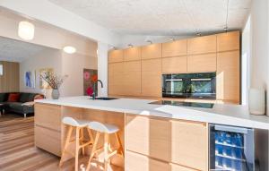 a kitchen with wooden cabinets and white counter tops at Beautiful Home In Ejstrupholm in Krejbjerg