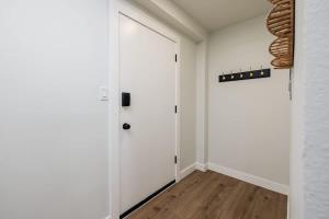 a hallway with a white door and a wooden floor at Inlet View Luxe -King Suite - Downtown Anchorage in Anchorage