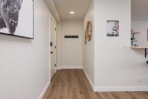 a hallway with white walls and wood floors at Inlet View Luxe -King Suite - Downtown Anchorage in Anchorage