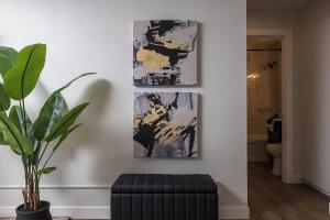 a living room with a plant and paintings on the wall at Inlet View Luxe -King Suite - Downtown Anchorage in Anchorage +17 photos