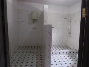 a bathroom with a shower with black and white tiles at Rams Lodge in Accra +24 photos